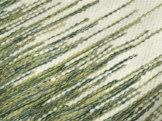 Green Big Wool Zig Zag handwoven wool tapestry shown hanging on a wall
