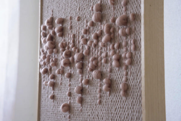 Teor handwoven wool tapestry shown hanging on a wall