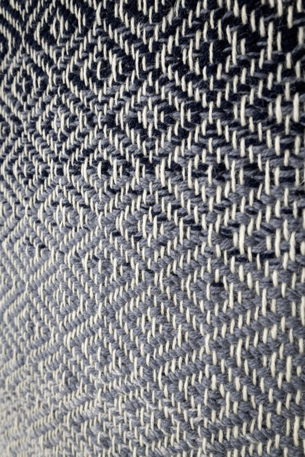 BLUO handwoven wool tapestry shown hanging on a wall