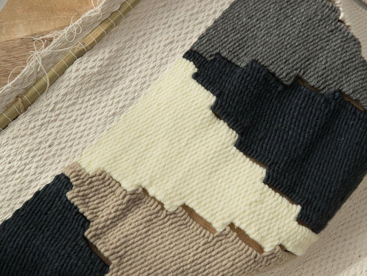 Triangul handwoven wool tapestry shown hanging on a wall