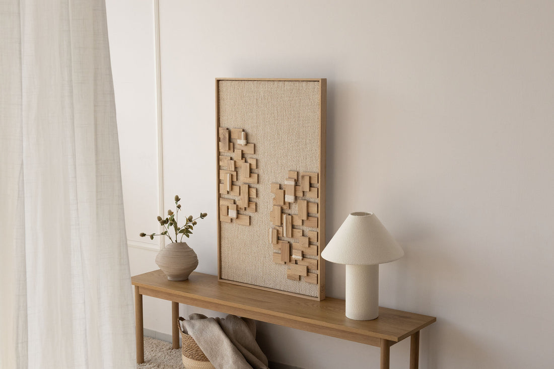 Japandi entryway with a framed handwoven wool and oak wall piece, a ceramic vase and warm neutral tones by Lale Studio