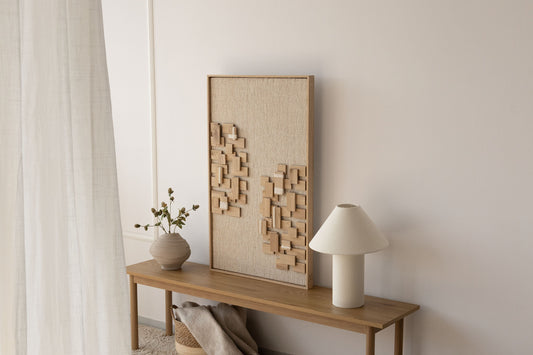 Japandi entryway with a framed handwoven wool and oak wall piece, a ceramic vase and warm neutral tones by Lale Studio