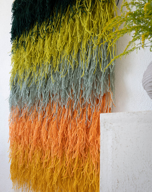 Calaia handwoven wool tapestry shown hanging on a wall