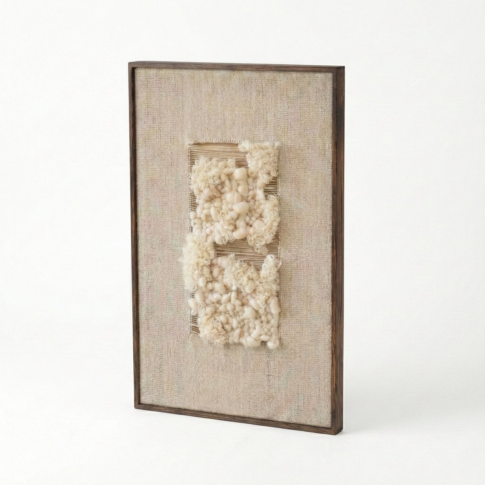 Decorative wall art with textured white elements in a brown frame on a white background