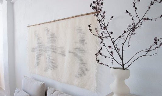 Zeva handwoven wool tapestry shown hanging on a wall
