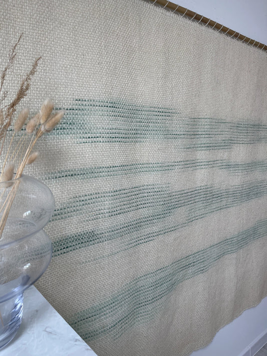 A'La Matcha handwoven wool tapestry shown hanging on a wall
