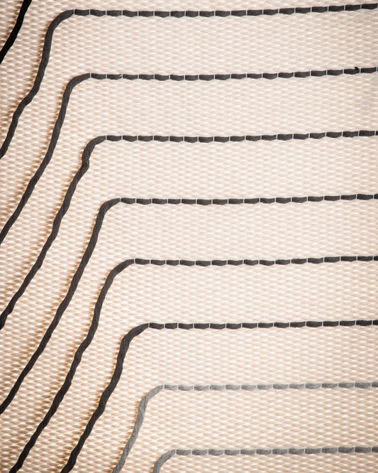 Gray Urania handwoven cotton tapestry shown hanging on a wall