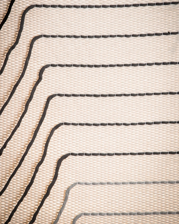 Gray Urania handwoven cotton tapestry shown hanging on a wall