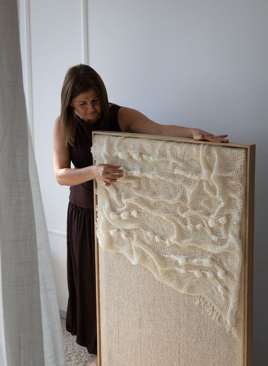 Aura handwoven wool tapestry shown hanging on a wall