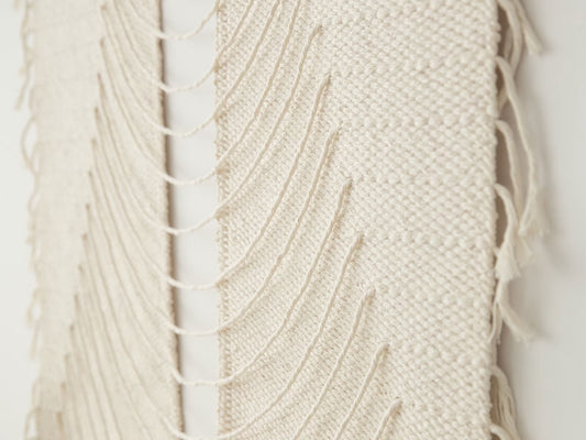 Urania Natural handwoven cotton tapestry shown hanging on a wall