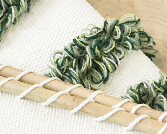 Green Luna handwoven wool tapestry shown hanging on a wall