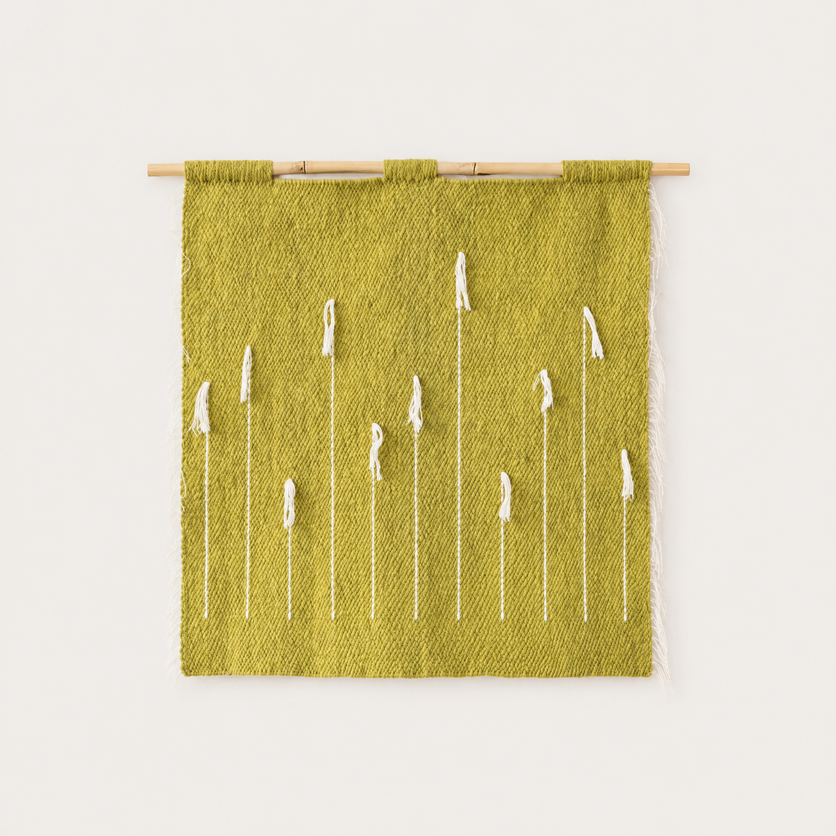 Green Denti di Leone handwoven olive wool wall hanging with white dandelion motif on bamboo rod, packshot, Lale Studio & Shop