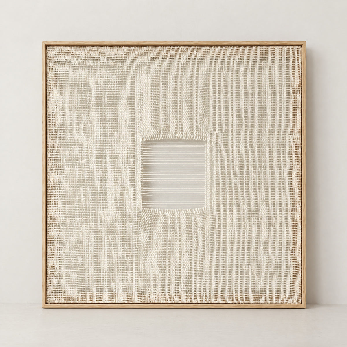 Diskuer framed ivory woven wall art with a central open square and fine horizontal threads, natural pine frame, full front view
