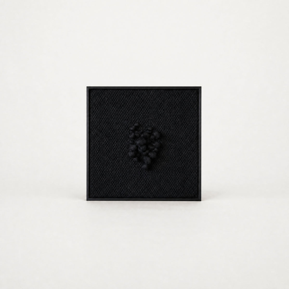Enigma sculptural handwoven two-ply wool tapestry in deep black with raised relief in a slim black ebony frame, framed textile wall art by Lale Studio & Shop