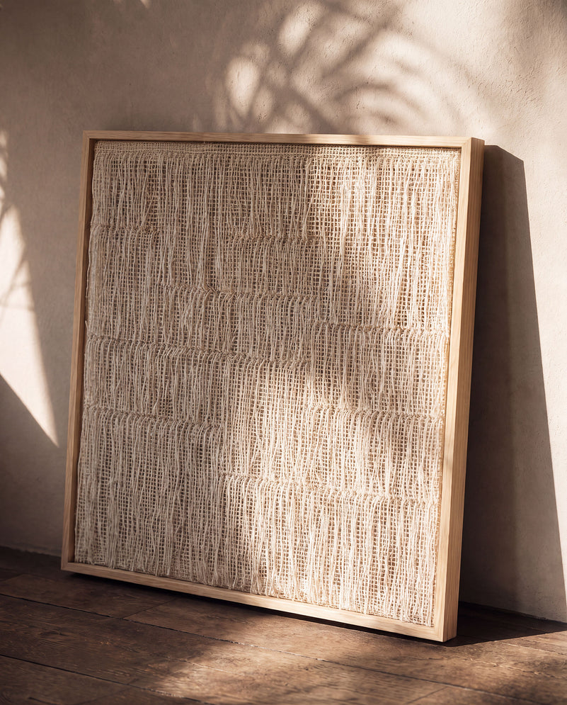Estheté framed textile wall art in two-ply wool leaning against a wall on a wooden floor, Scandinavian decor by Lale Studio & Shop