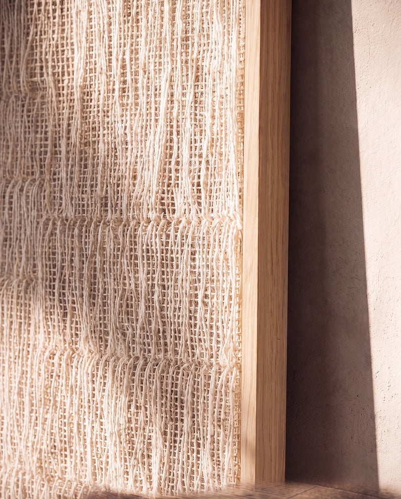 Detail of Estheté handwoven two-ply wool textile with vertical threads meeting the wood frame edge, by Lale Studio & Shop