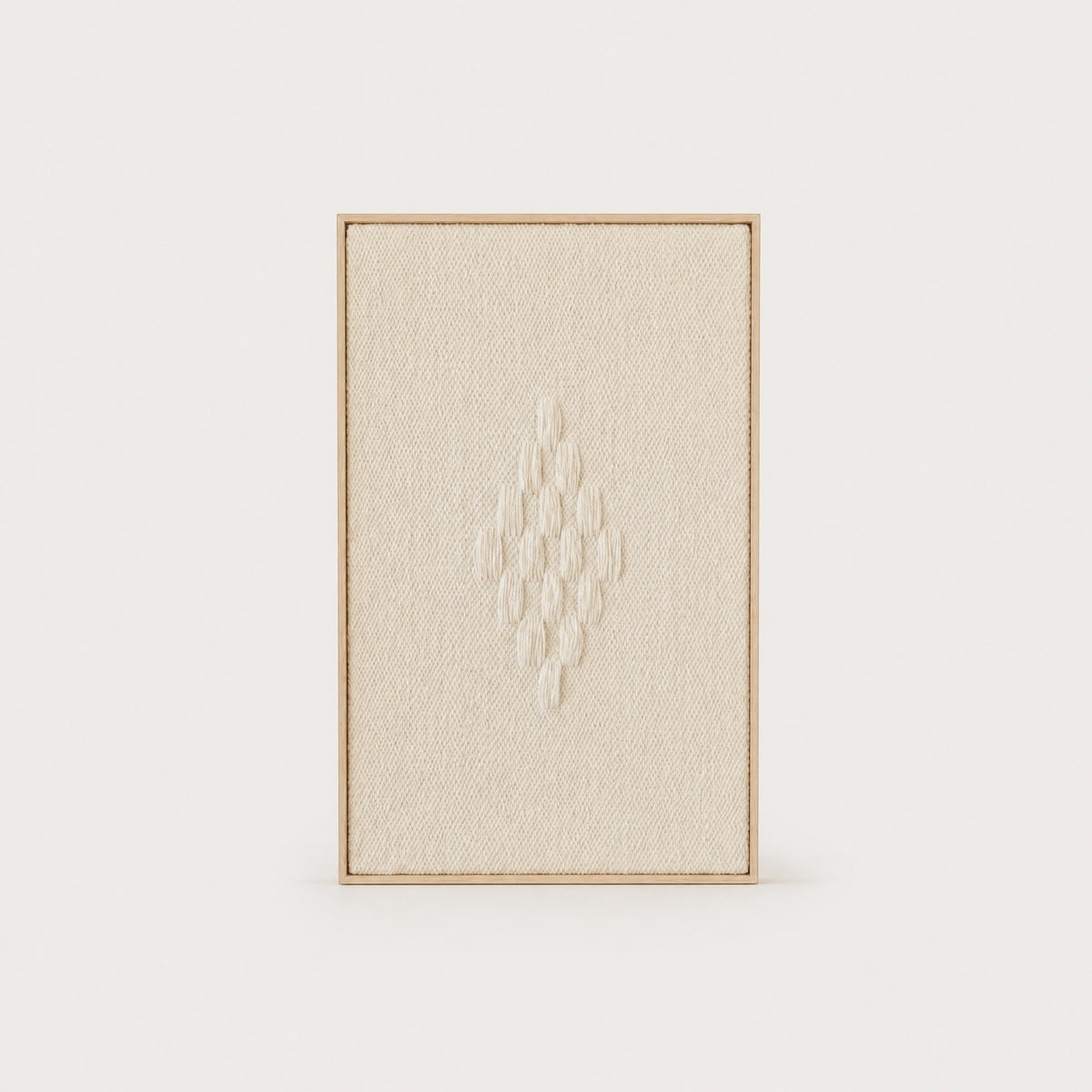 Framed 7 handwoven wool tapestry in soft natural cream with a raised diamond motif in a slim pine frame, framed textile wall art by Lale Studio & Shop