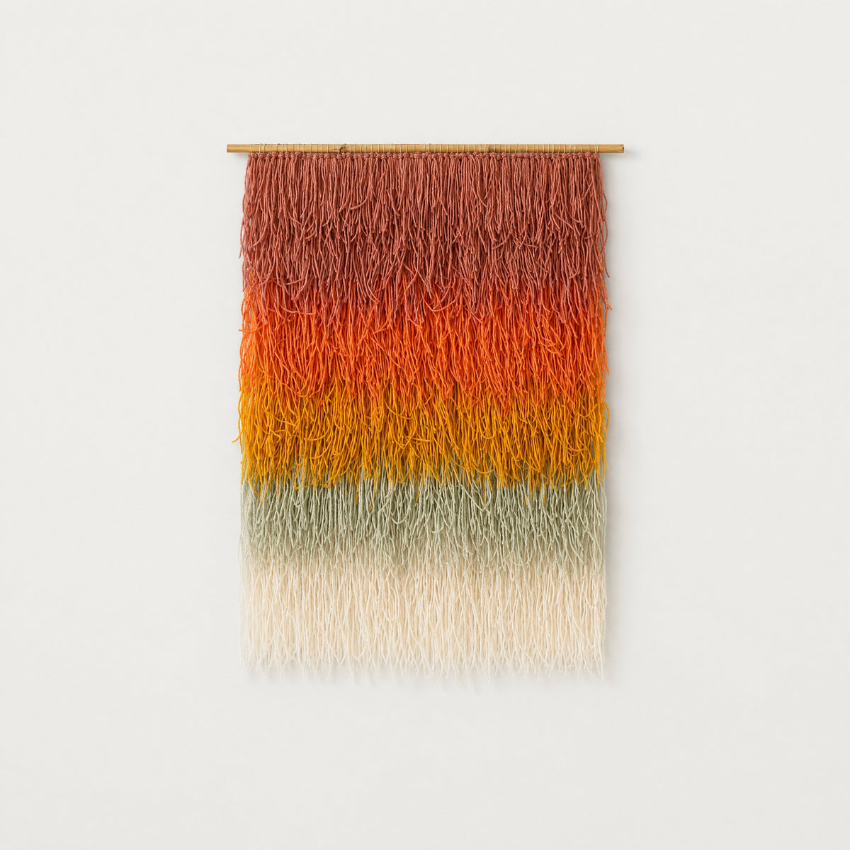 Gerbena handwoven multicolor ombre shaggy wool wall hanging on a bamboo rod, terracotta to sage gradient studio packshot — Lale Studio & Shop