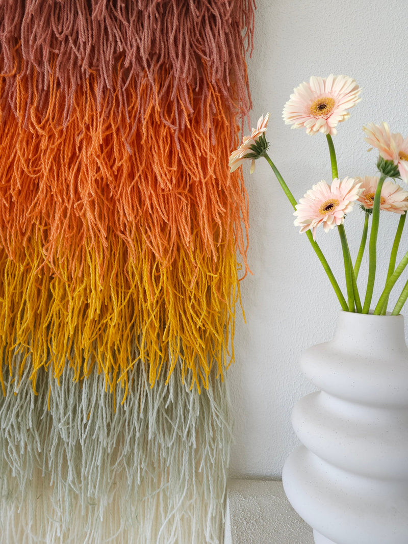 Detail of Gerbena's cream and sage lower fringe against the warm gradient — handwoven wool tapestry by Lale Studio & Shop