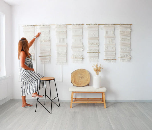 Teide 7 seven panel woven wall hanging shown at full scale on a wall with a person adjusting the panels