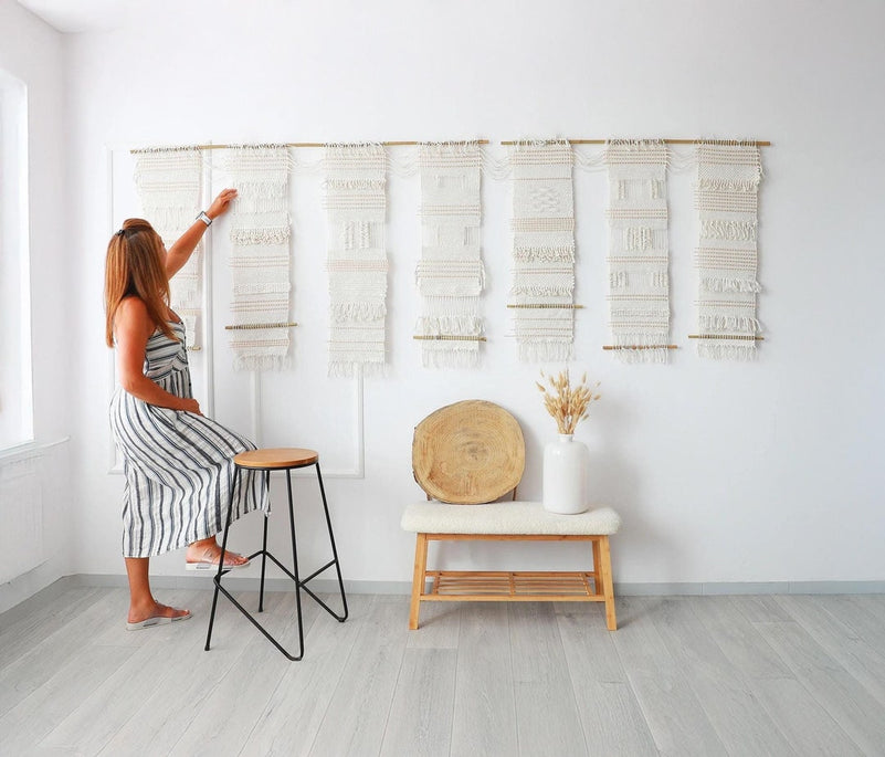 Teide 7 seven panel woven wall hanging shown at full scale on a wall with a person adjusting the panels