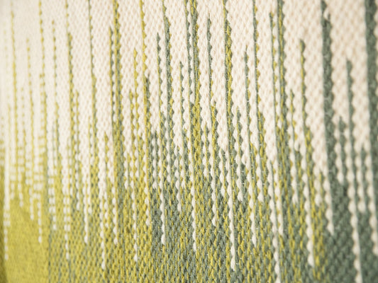 Vero handwoven wool tapestry shown hanging on a wall