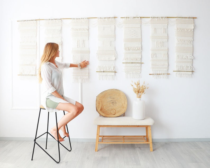 Teide 7 handwoven seven panel wall hanging with a person seated in front, showing scale