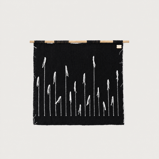 Black Denti di Leone handwoven wall hanging in black and white on a bamboo rod, Lale Studio & Shop