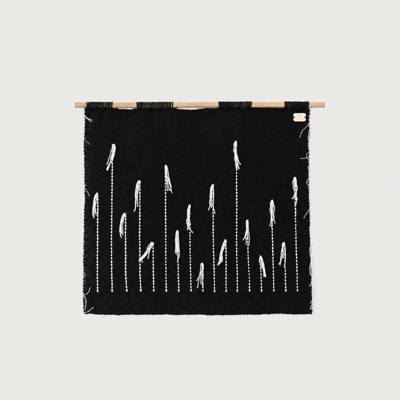 Black Denti di Leone handwoven wall hanging in black and white on a bamboo rod, Lale Studio & Shop