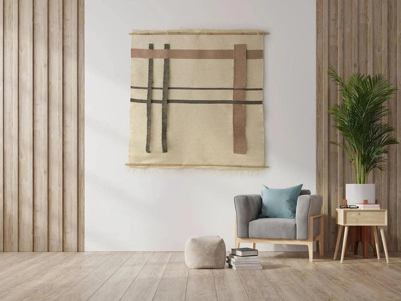 Krado handwoven wool wall hanging in beige, brown and charcoal on bamboo rods, shown beside a reading chair with the original pattern orientation, Lale Studio & Shop