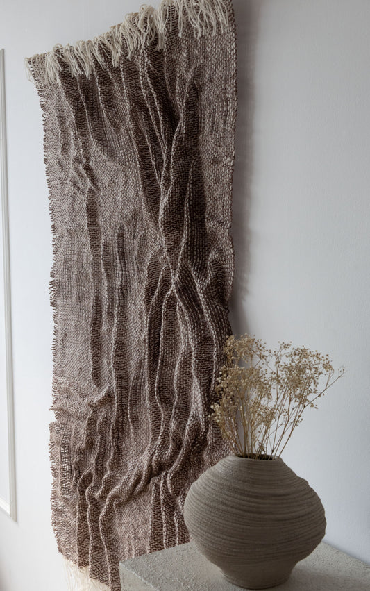 Lutum handwoven wool tapestry shown hanging on a wall