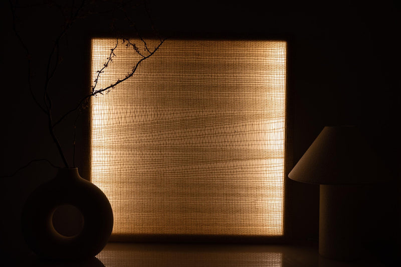 Ma textile light glowing warmly through an open wool weave in a dark atmospheric interior