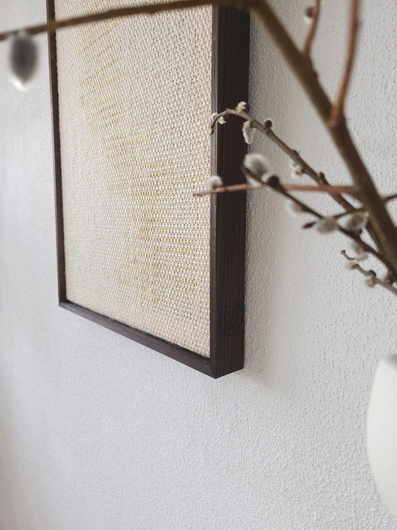 Millip framed tapestry on a neutral wall, minimalist interior