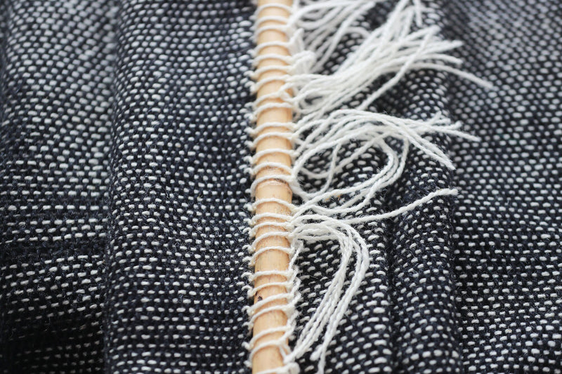 Misty Ink dark woven wall hanging styled in a minimalist Scandinavian living room