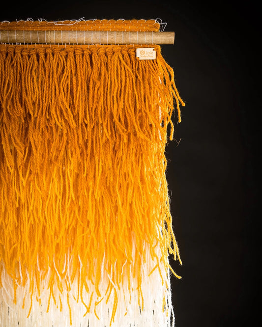 Saule handwoven wool tapestry shown hanging on a wall