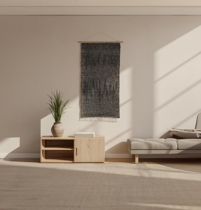 Nyora charcoal and black tapestry styled above a sideboard in a modern interior — handwoven wall hanging by Lale Studio & Shop