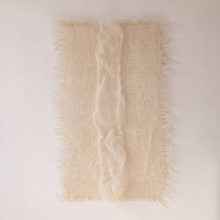 Perfecta ivory woven wall hanging, full front view with raw fringes on both sides and a delicate central wave