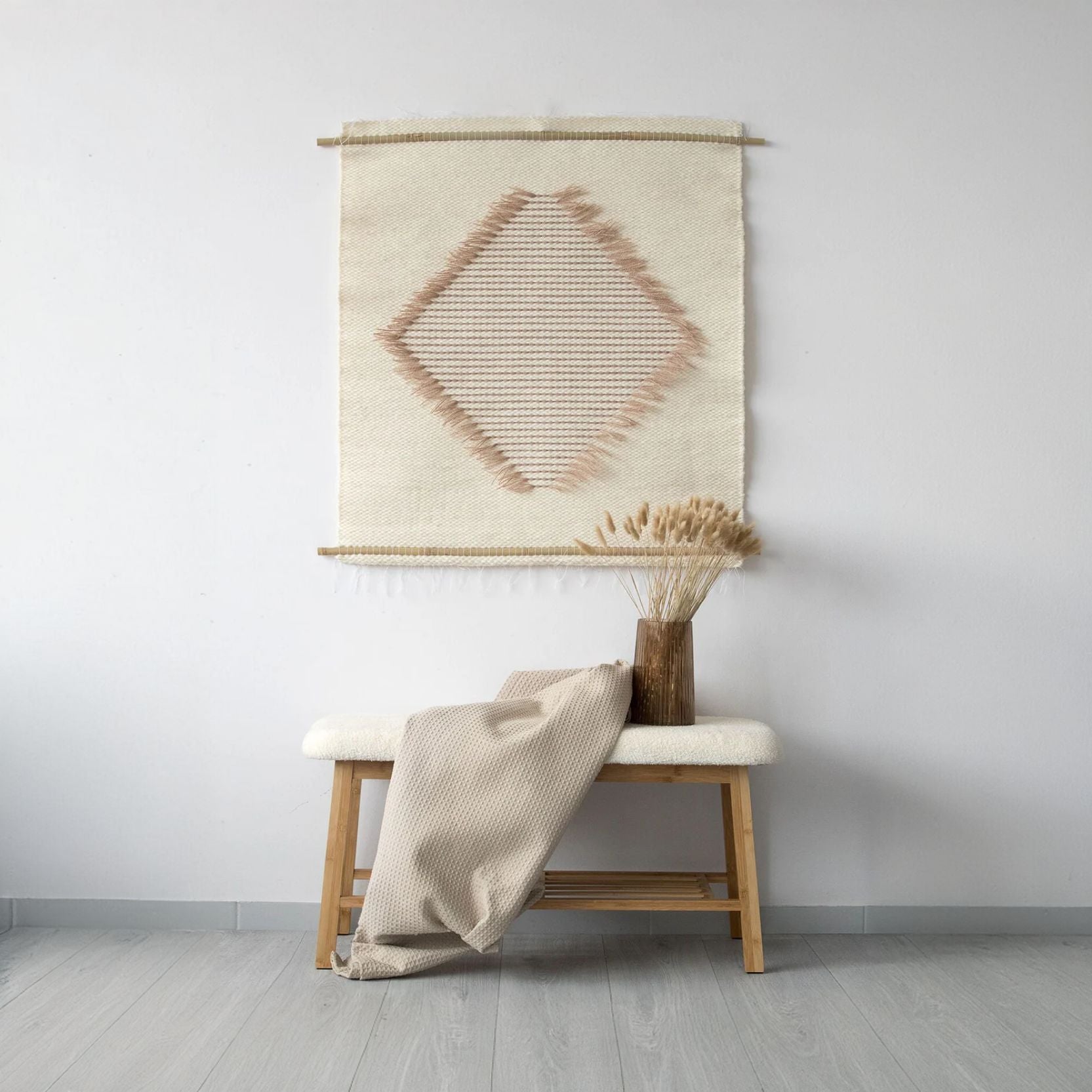 Rombo S handwoven tapestry with a diamond pattern in natural wool and beige tones, featuring light brown accents. A smaller yet elegant centerpiece perfect for minimalist and boho interiors.