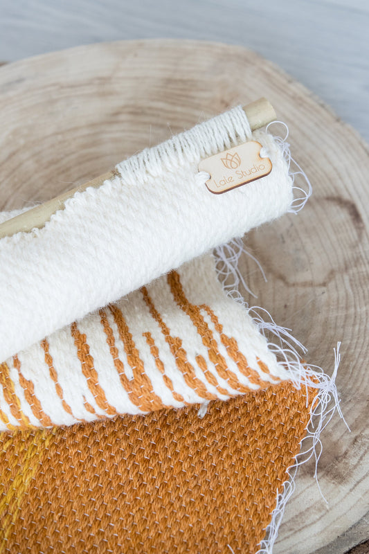 Sune woven wall hanging styled in a bright modern living room, warm orange and yellow tones