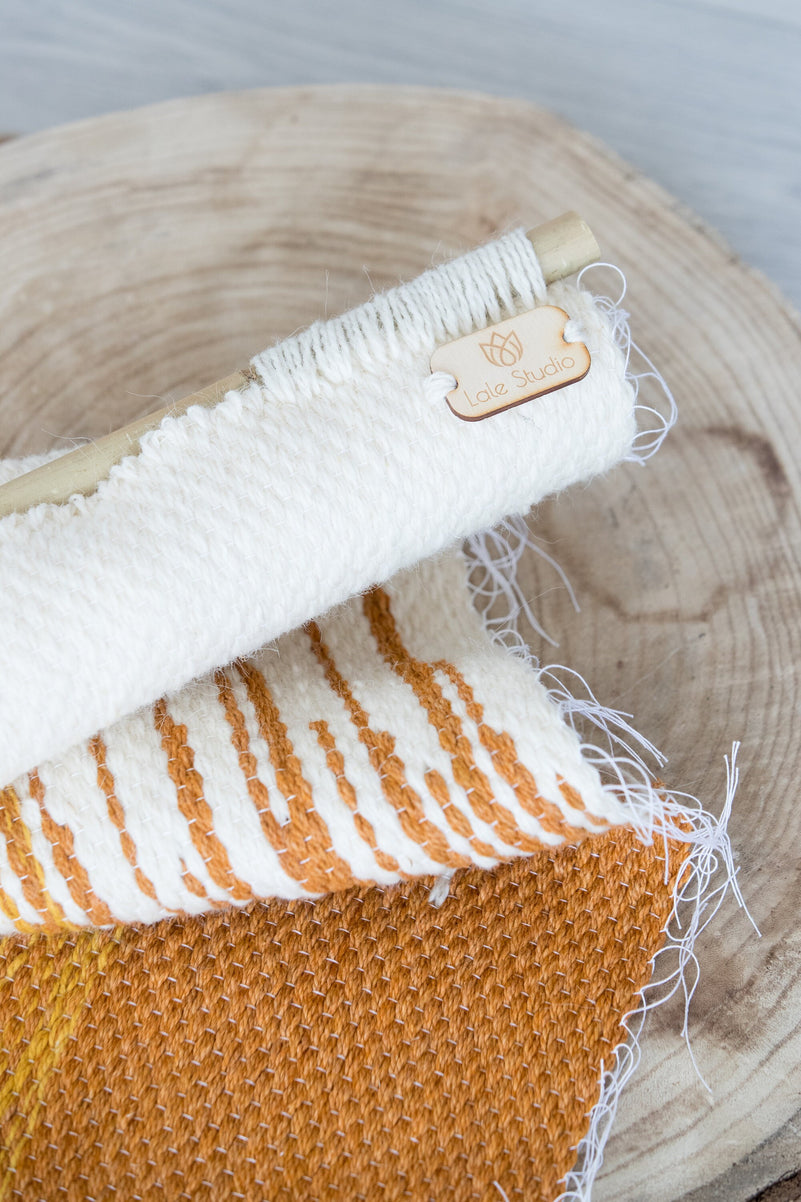 Sune woven wall hanging styled in a bright modern living room, warm orange and yellow tones