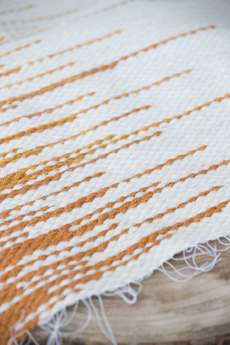 Sune tapestry hanging on a neutral wall, minimalist interior